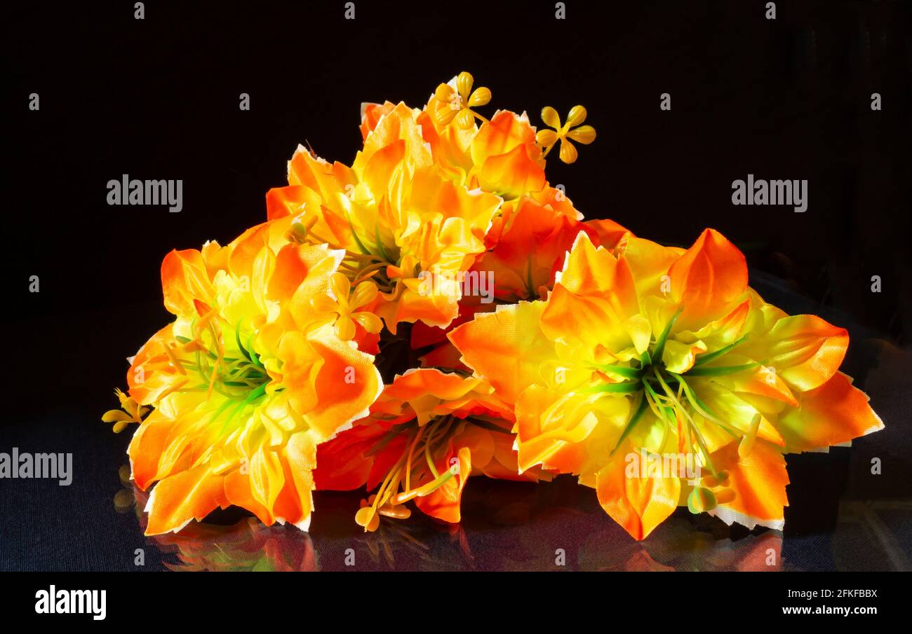 Fleurs artificielles.arrière-plan magnifique et lumineux. Photo couleur horizontale. Bouquet sur fond noir Banque D'Images