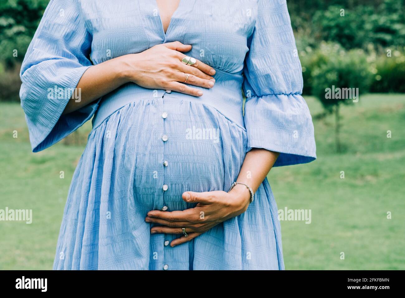 Femme enceinte méconnue qui tient son ventre pendant le troisième trimestre Banque D'Images