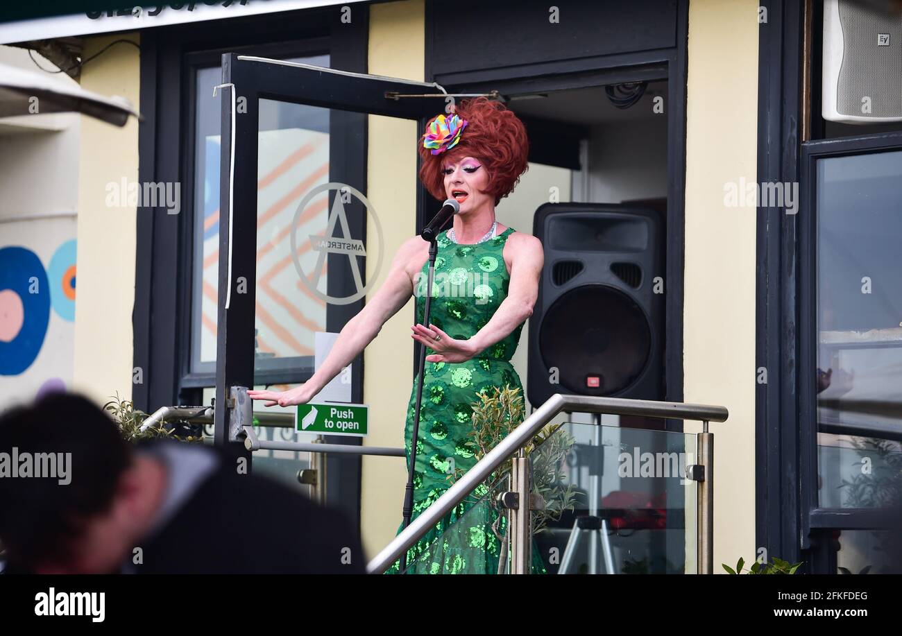 Brighton Royaume-Uni 1er mai 2021 - UNE reine de drag s'amusent devant un bar de bord de mer de Brighton pendant que les gens apprécient le week-end des vacances de mai avec des choses qui reviennent progressivement à la normale en Angleterre avec des restrictions de verrouillage permettant aux lieux d'accueil de servir des boissons en plein air : Credit Simon Dack / Alay Live News Banque D'Images