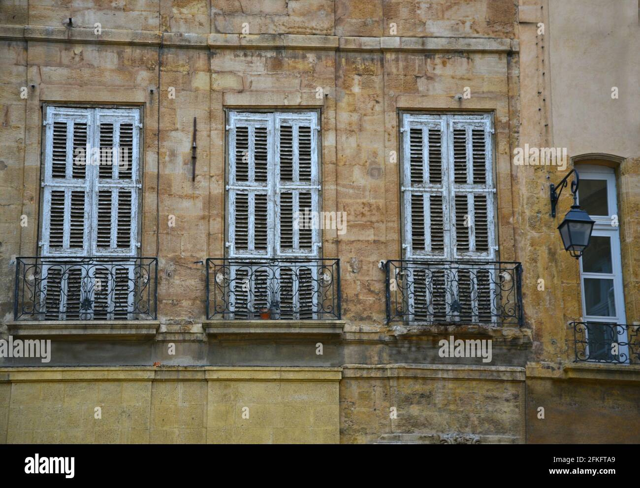 Façade de style provençal avec mur en pierre, volets bleu clair et balustrade de balcon en fer fait à la main à Aix-en-Provence Marseille, France. Banque D'Images