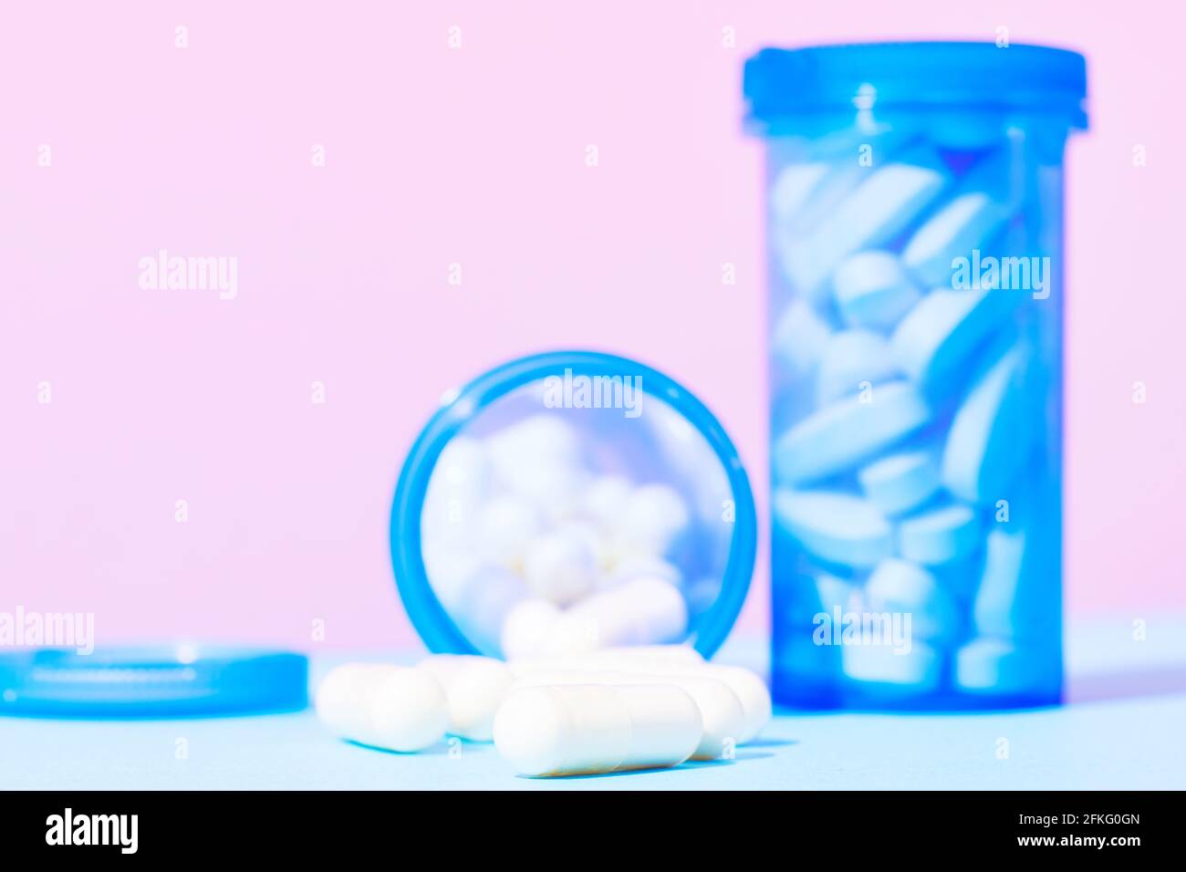 Flacons de pilules et capsules de médicaments sur fond rose Banque D'Images