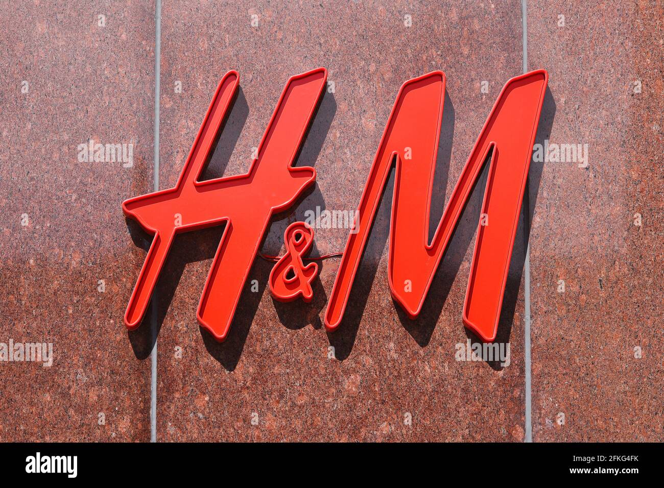 Stockholm, Suède - 30 avril 2021 : gros plan de l'enseigne H&M au-dessus de l'entrée de la boutique de vêtements. Banque D'Images