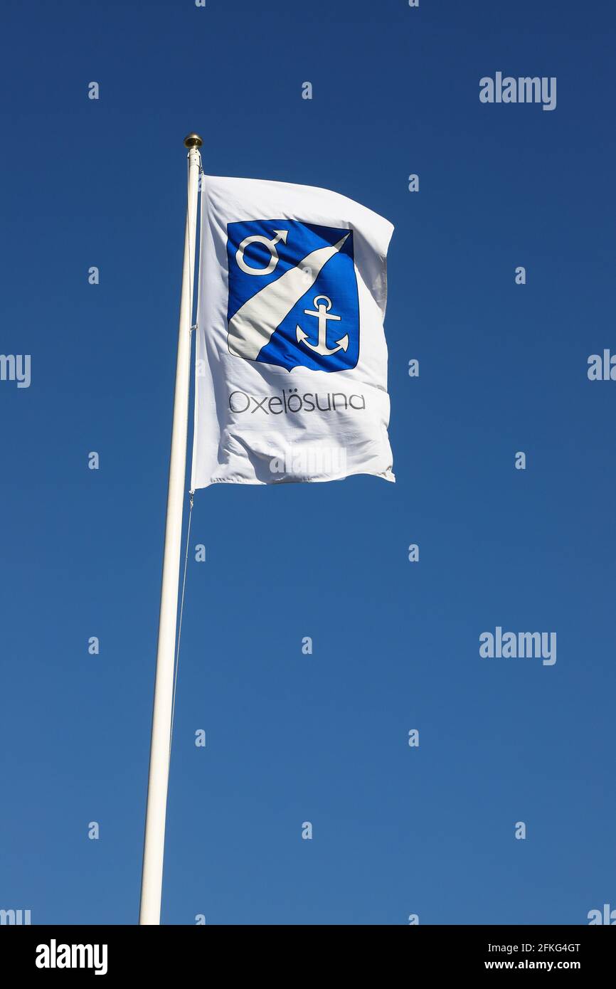 Oxelosund, Suède - 18 avril 2021 : les armoiries municipales d'Oxelsund sur un drapeau bleu clair. Banque D'Images