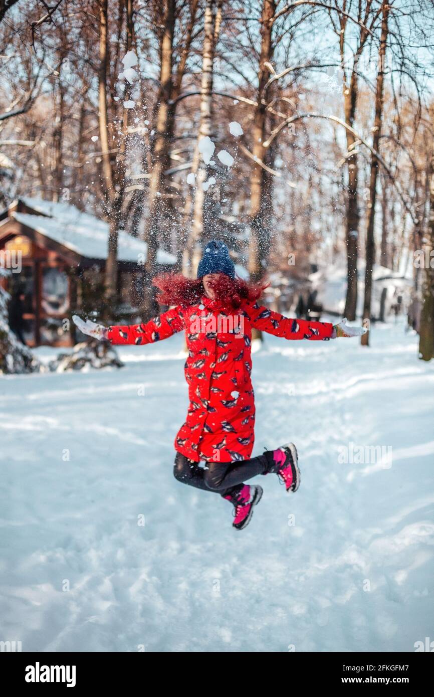 Bonne jeune femme sautant dans la neige Banque D'Images
