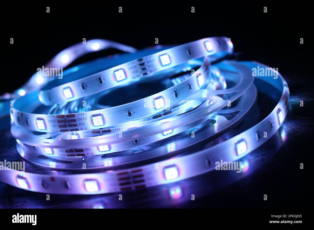 Gros plan d'une bande de silicone à LED avec lumières bleues sur fond noir Banque D'Images