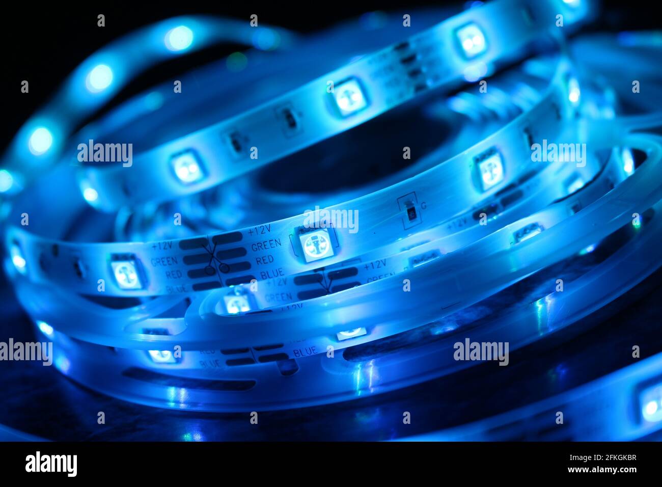 Gros plan d'une bande de silicone à LED avec lumières bleues sur fond noir Banque D'Images