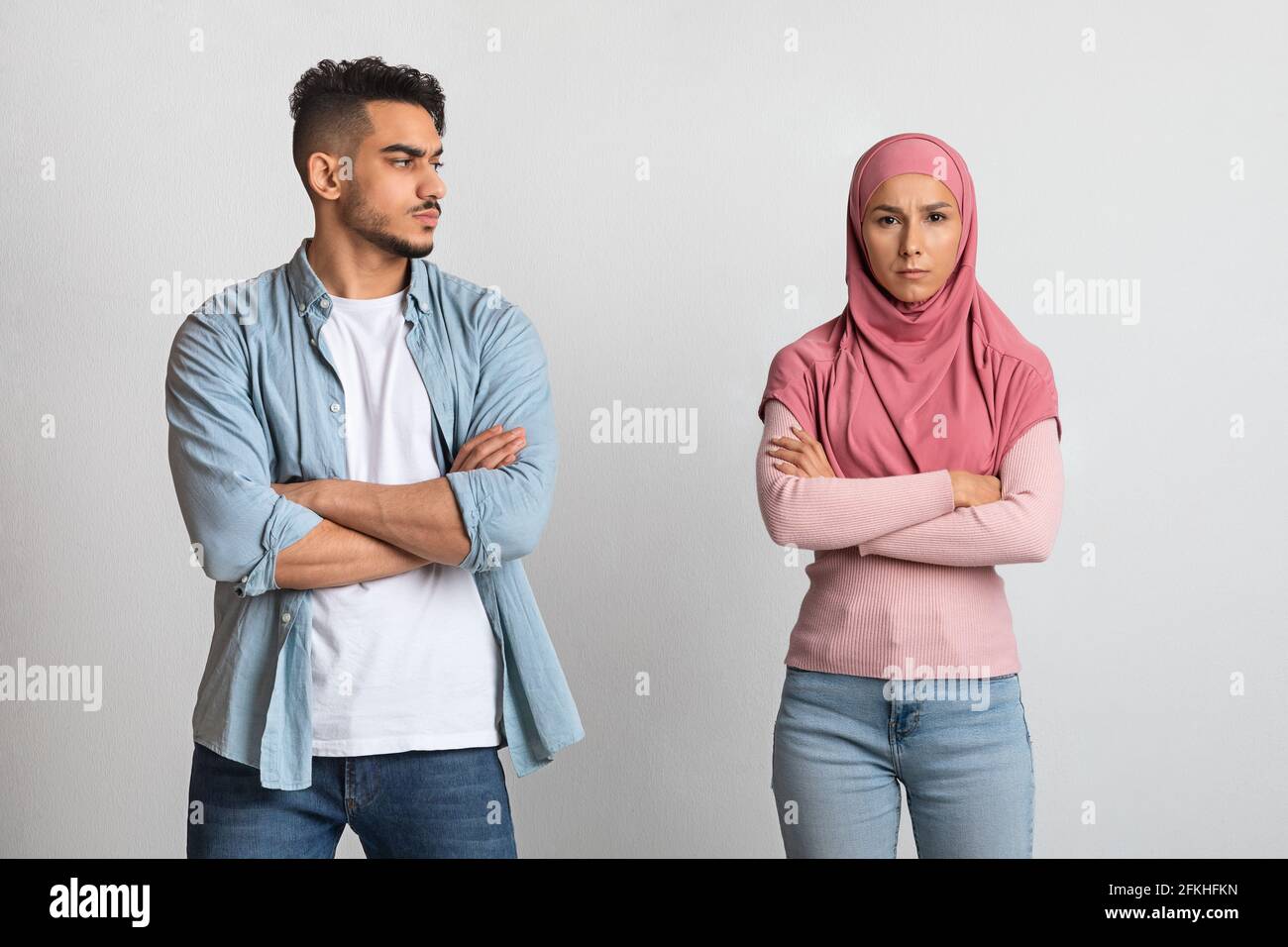 Triste homme arabe regardant une femme musulmane offensé dans le hijab après la querelle Banque D'Images