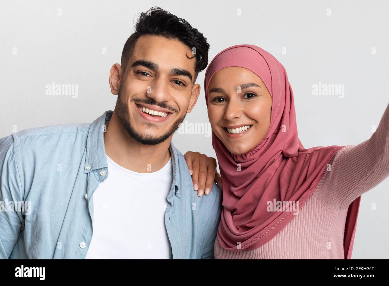 Joyeux jeune homme arabe et femme musulmane dans la prise de hijab Selfie ensemble Banque D'Images