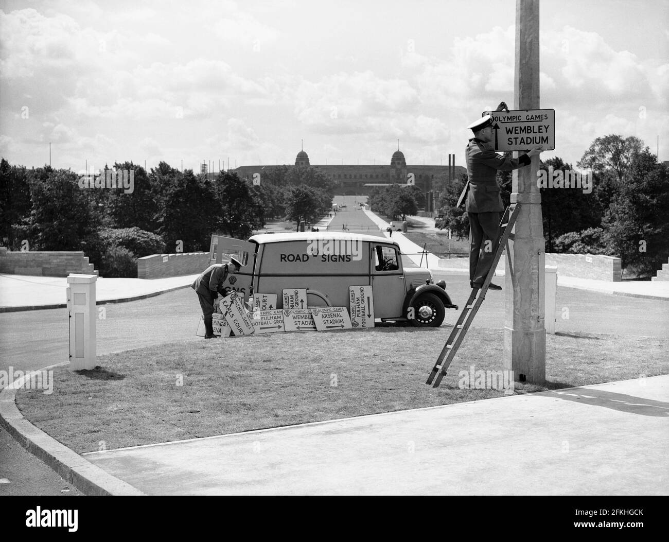 Photo du dossier datée du 1/5/1948 des travailleurs qui mettent des affiches à Londres pour diriger les gens vers les divers lieux associés aux Jeux Olympiques. Wembley Park, le quartier de divertissement de renommée mondiale de Londres, a connu des changements importants au cours des 70 dernières années, avec les nouvelles étapes olympiques qui ont marqué la dernière pièce du puzzle dans le développement de l'emblématique voie olympique, également connue sous le nom de « Wembley Way ». Date de publication : dimanche 2 mai 2021. Banque D'Images