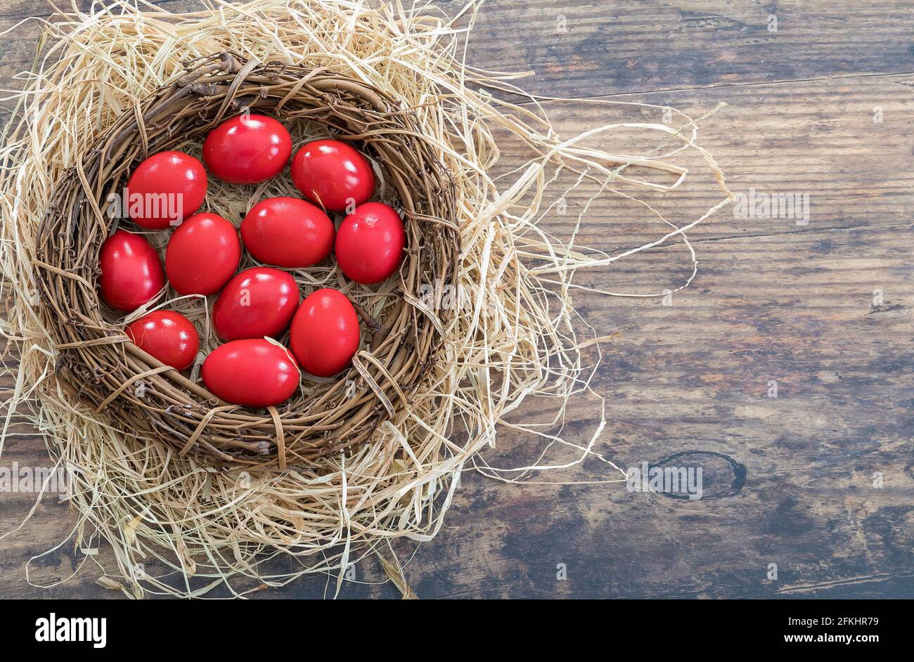 Œufs peints en rouge traditionnels posés sur un décor en paille pour la fête grecque orthodoxe de Pâques. Image de stock. Banque D'Images