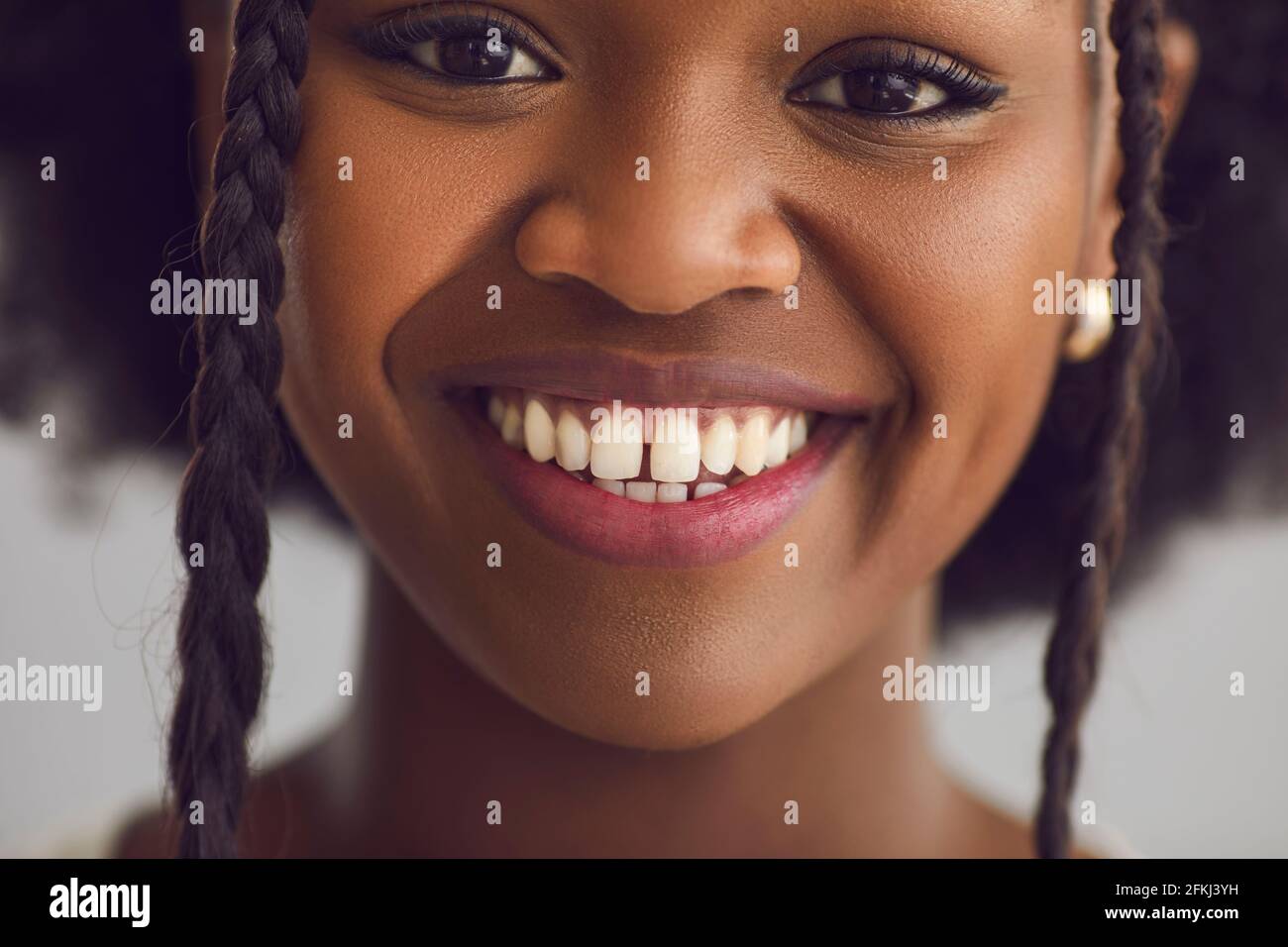 Une adolescente afro-américaine sourit en gros plan portrait en studio arrière-plan Banque D'Images