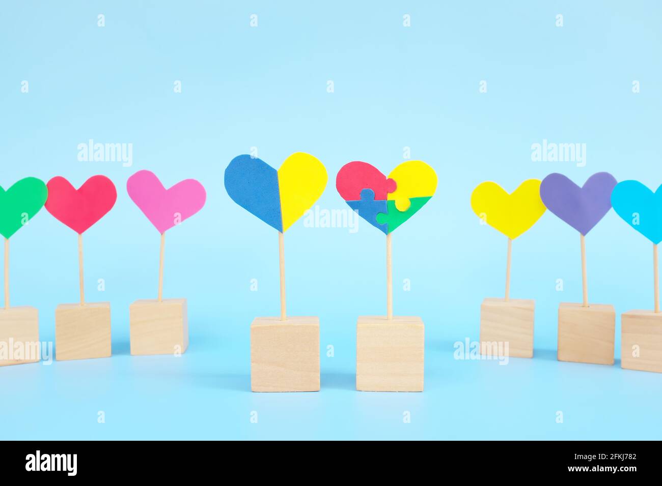 Concept de l'enfant avec le trouble du spectre autistique et le syndrome de Down égalité, diversité et inclusion dans la société. Forme de coeur de puzzle parmi multicolore Banque D'Images