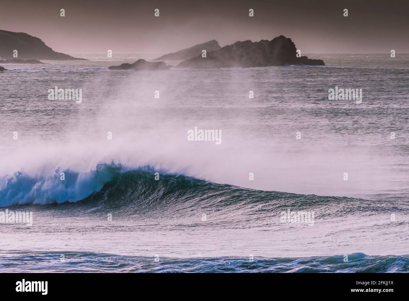 Une forte pulvérisation de vent au large d'une grande vague dans la baie de Fistral, à Newquay, dans les Cornouailles. Banque D'Images