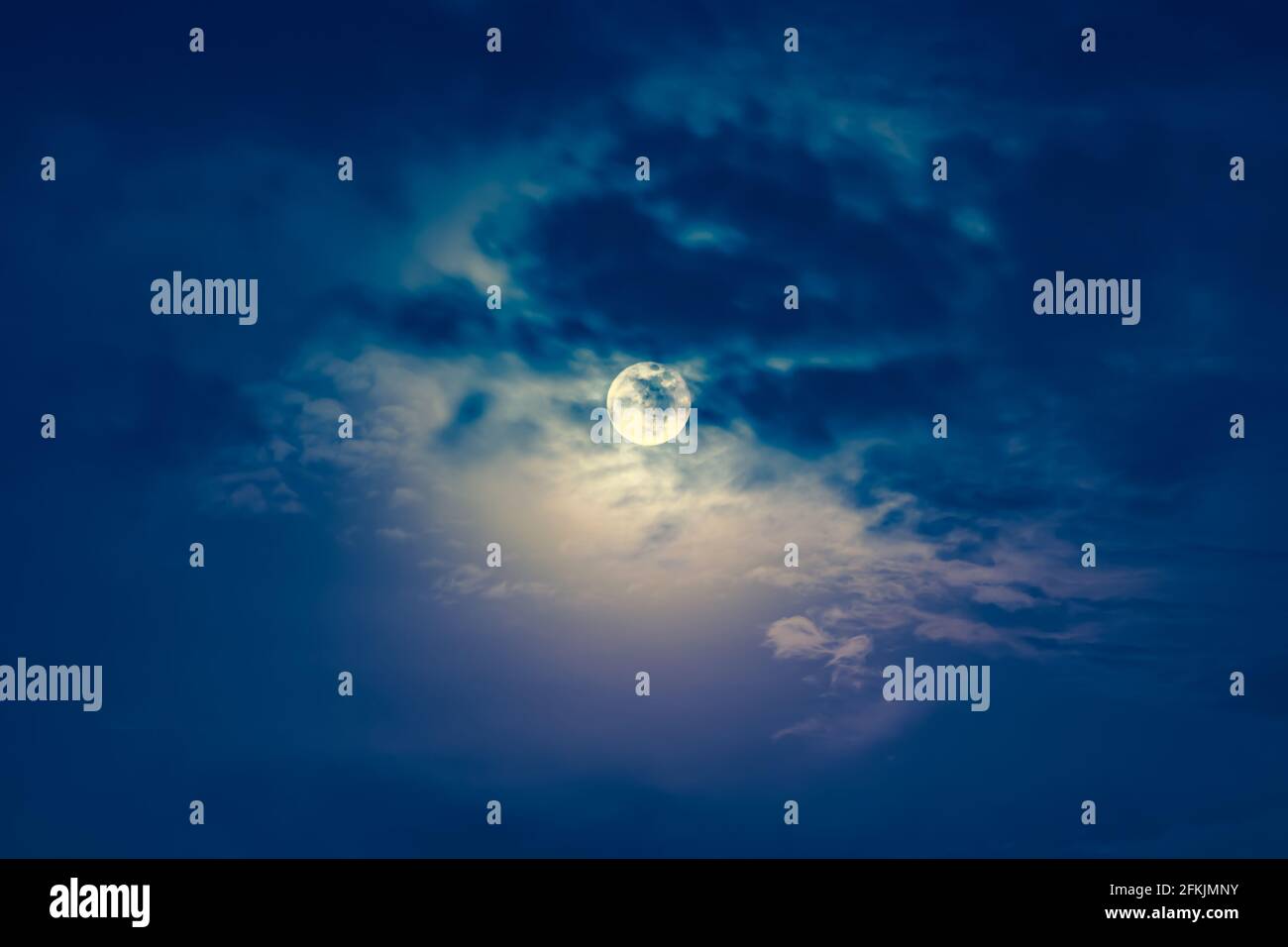 Arrière-plan du ciel nocturne avec nuage et pleine lune avec brillant. Beauté naturelle la nuit avec une magnifique lune derrière le nuage. Processus croisé et vintage Banque D'Images