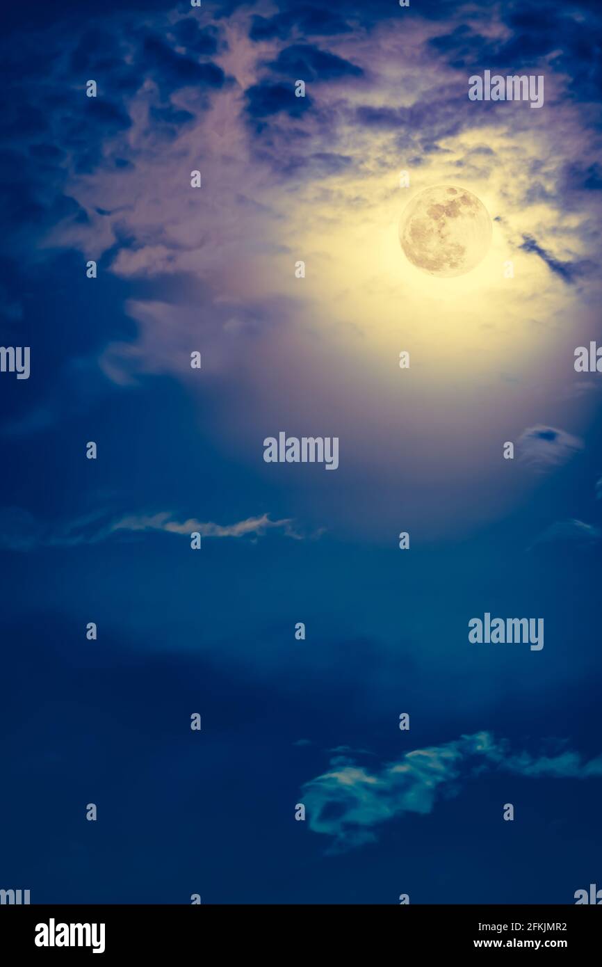 Arrière-plan du ciel nocturne avec nuage et pleine lune brillante avec brillant. Beauté naturelle la nuit avec magnifique pleine lune derrière le nuage. Effet vintage Banque D'Images