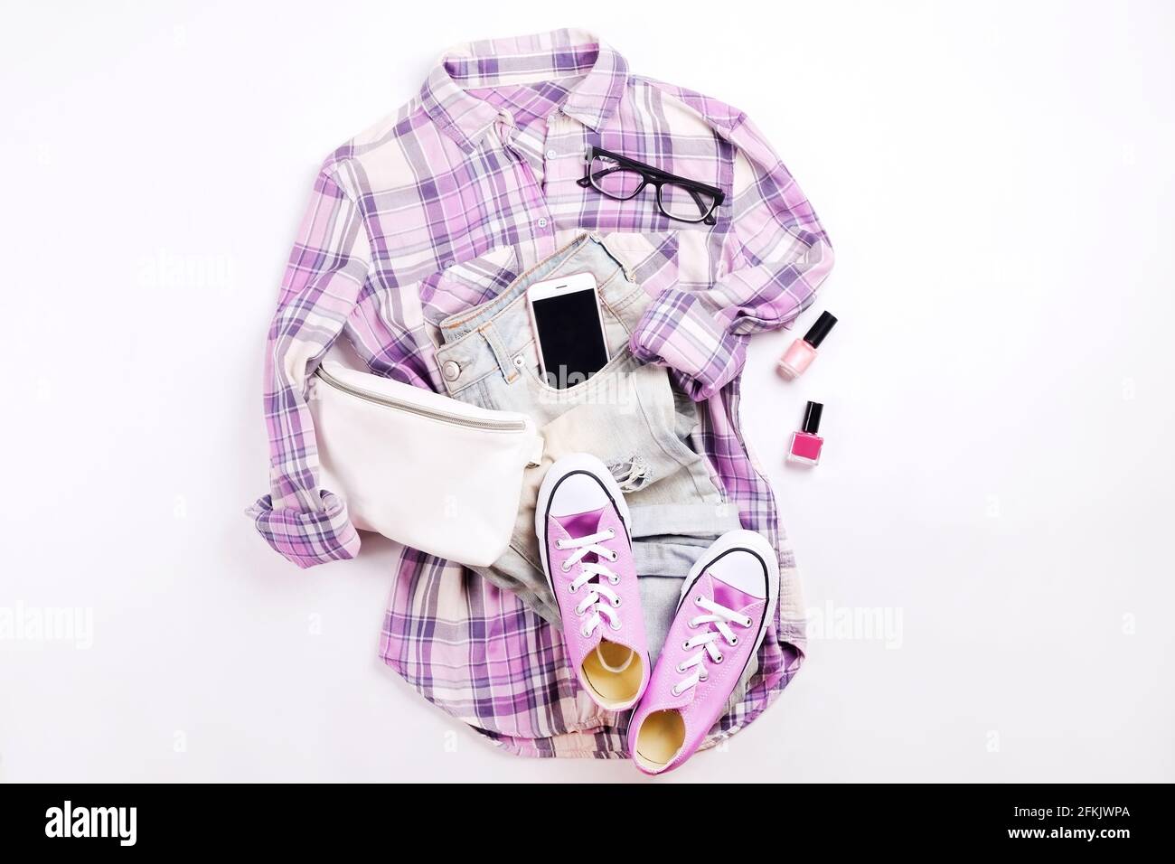 Soldes internationaux pour la journée des femmes. Vêtements et accessoires pour femme, collection printemps été. Chemise à carreaux violettes, baskets décontractées assorties. Fanny pa Banque D'Images