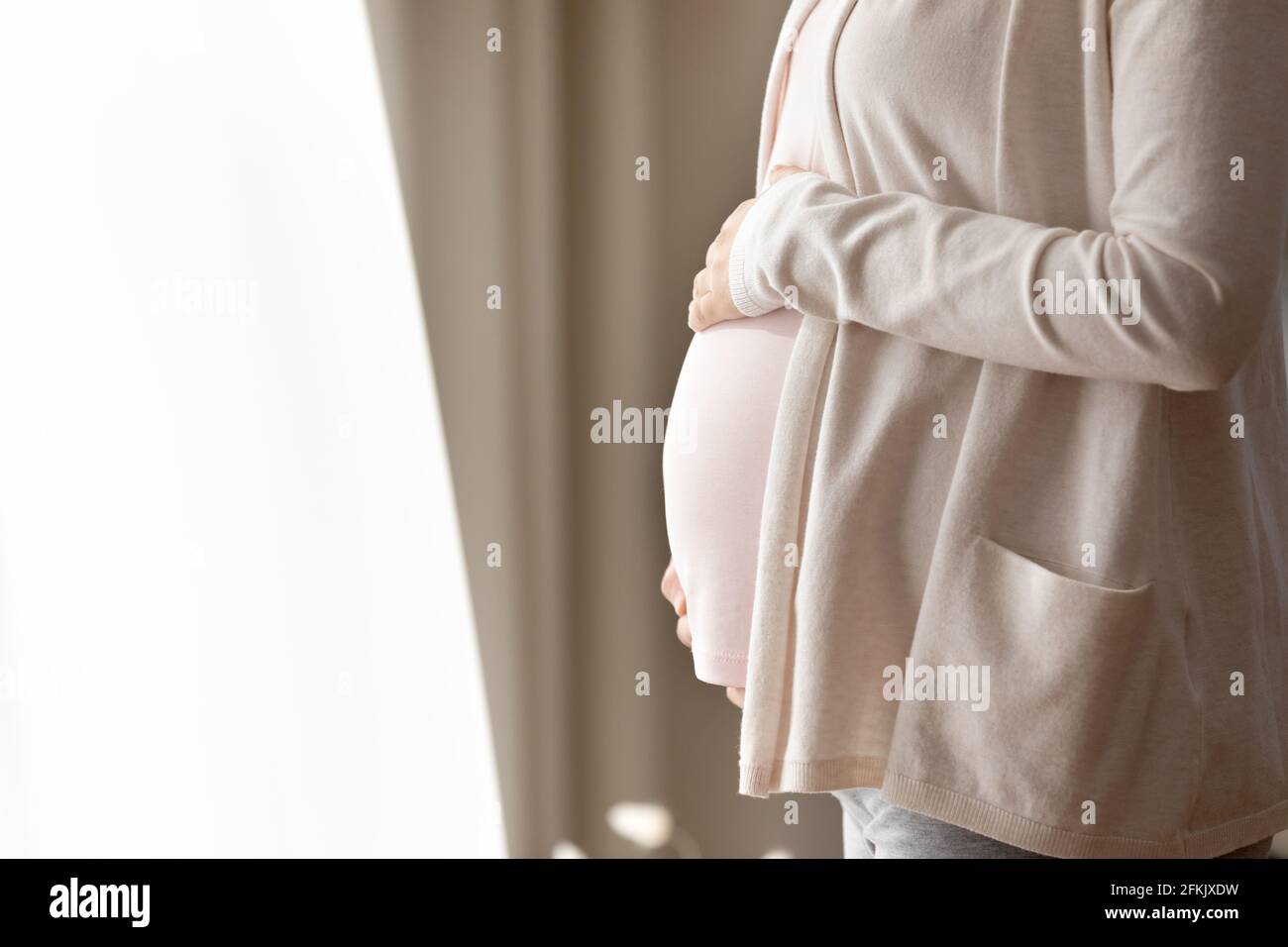 Gros plan de la femme enceinte caresse le ventre Banque D'Images