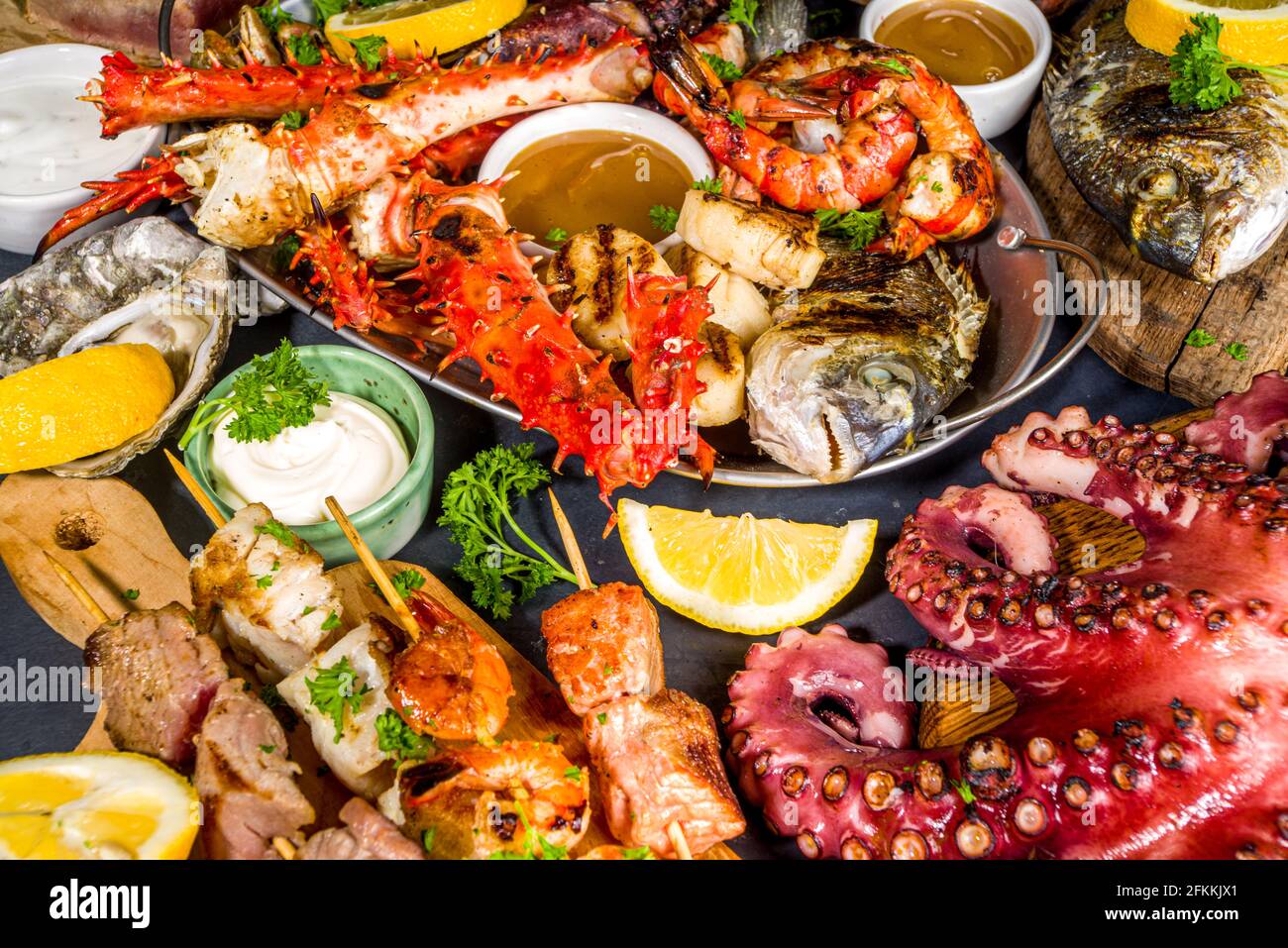 Assortiment divers barbecue cuisine méditerranéenne - poisson, pieuvre, crevettes, crabe, fruits de mer, moules, repas d'été barbecue fête, avec kebab, sauces, Banque D'Images