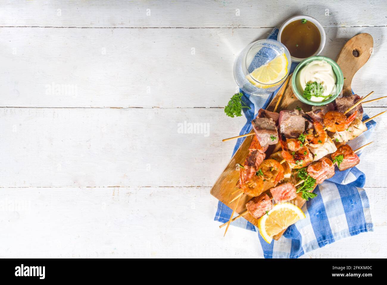 Assortiment divers barbecue cuisine méditerranéenne - poisson, crevettes, crabe, moules, kebabs avec sauces, arrière-plan en bois blanc, au-dessus de l'espace de copie Banque D'Images