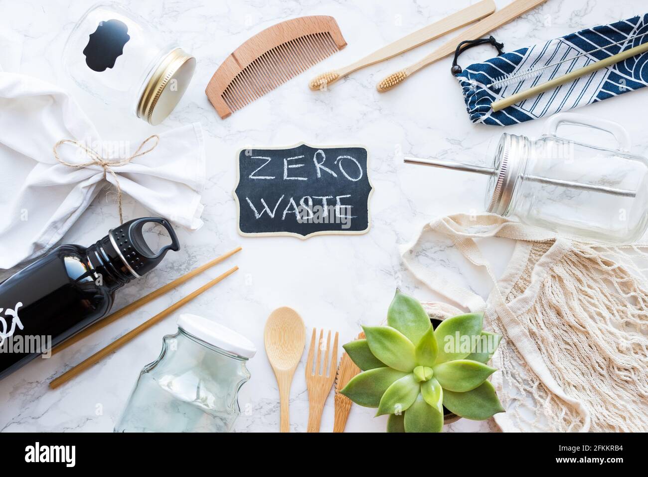 Concept zéro déchet. Sacs en coton, couverts en bambou et brosses à dents, pots en verre et bouteille d'eau en métal sur fond de marbre. Vie durable. Réfrigérateur ECO Banque D'Images