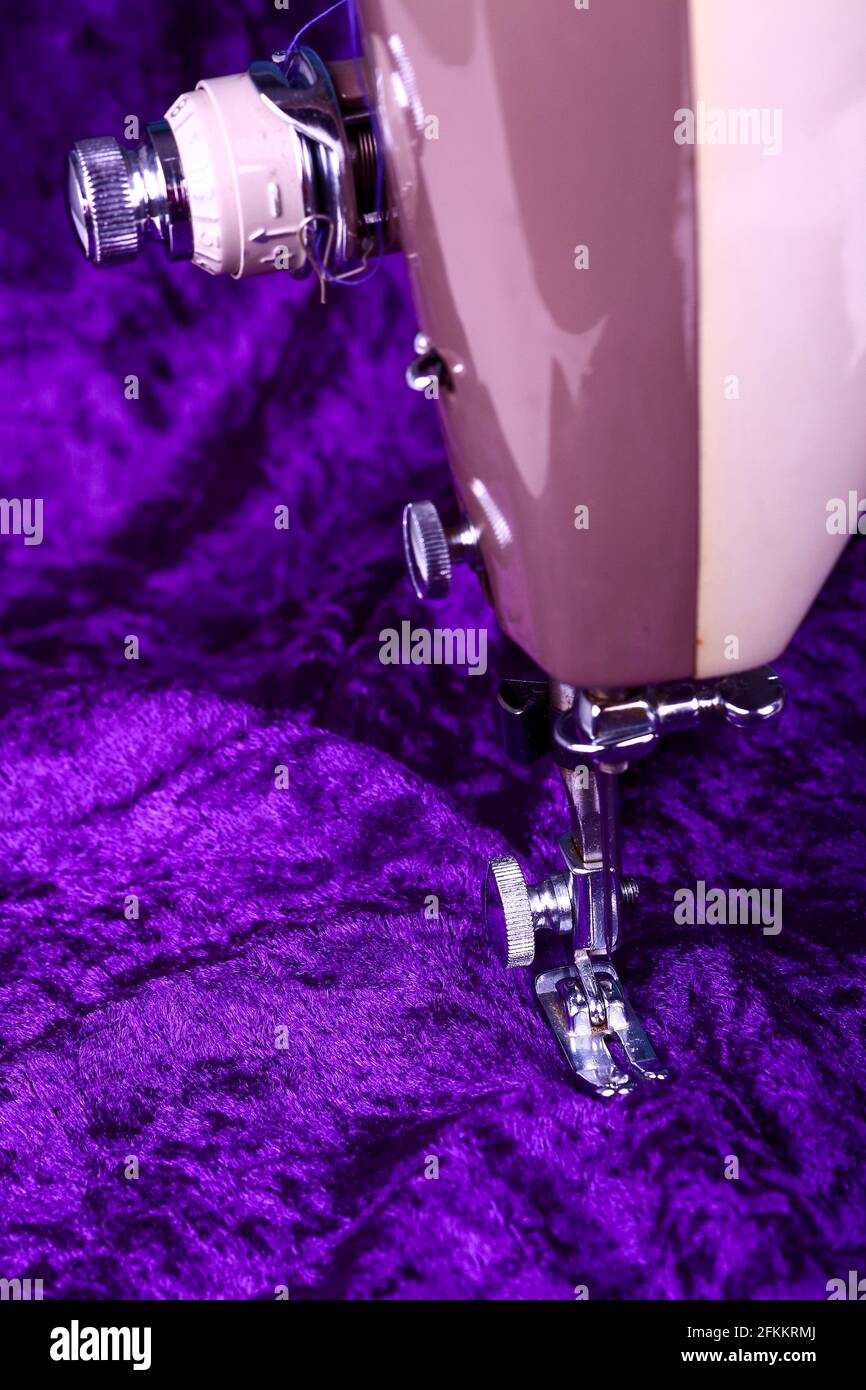 Tissu violet de velours écrasé avec un gros plan d'un machine à coudre vintage Banque D'Images