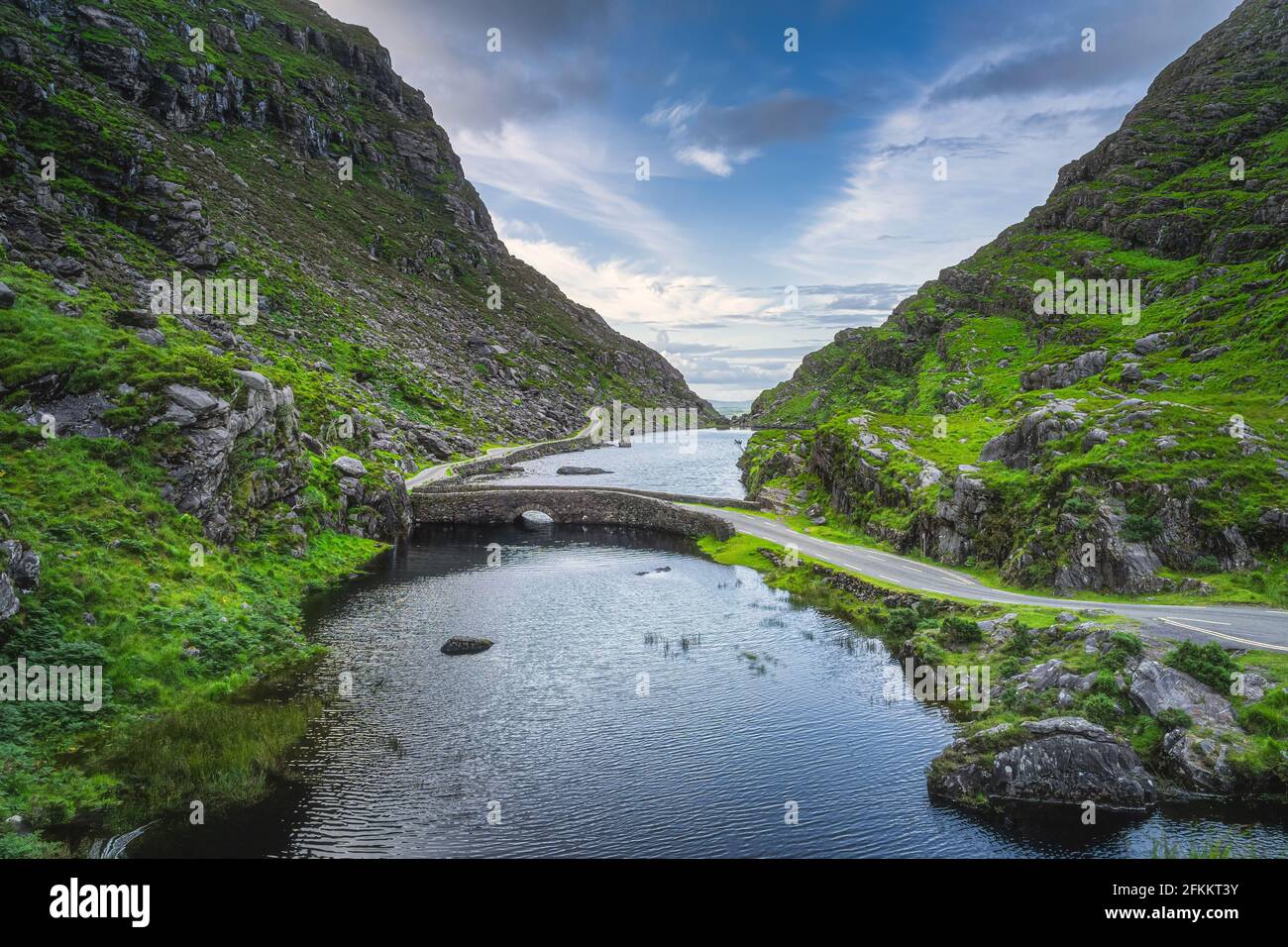 Chemin étroit et sinueux traversant le pont en pierre à Gap of Dunloe, Black Valley, montagnes MacGillycuddys Reeks, Ring of Kerry, Irlande Banque D'Images