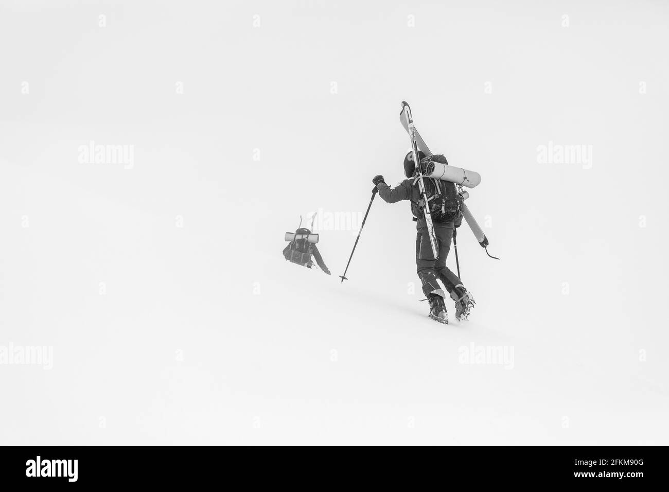 Le skieur marche sur la glace avec des crampons portant ses skis Banque D'Images