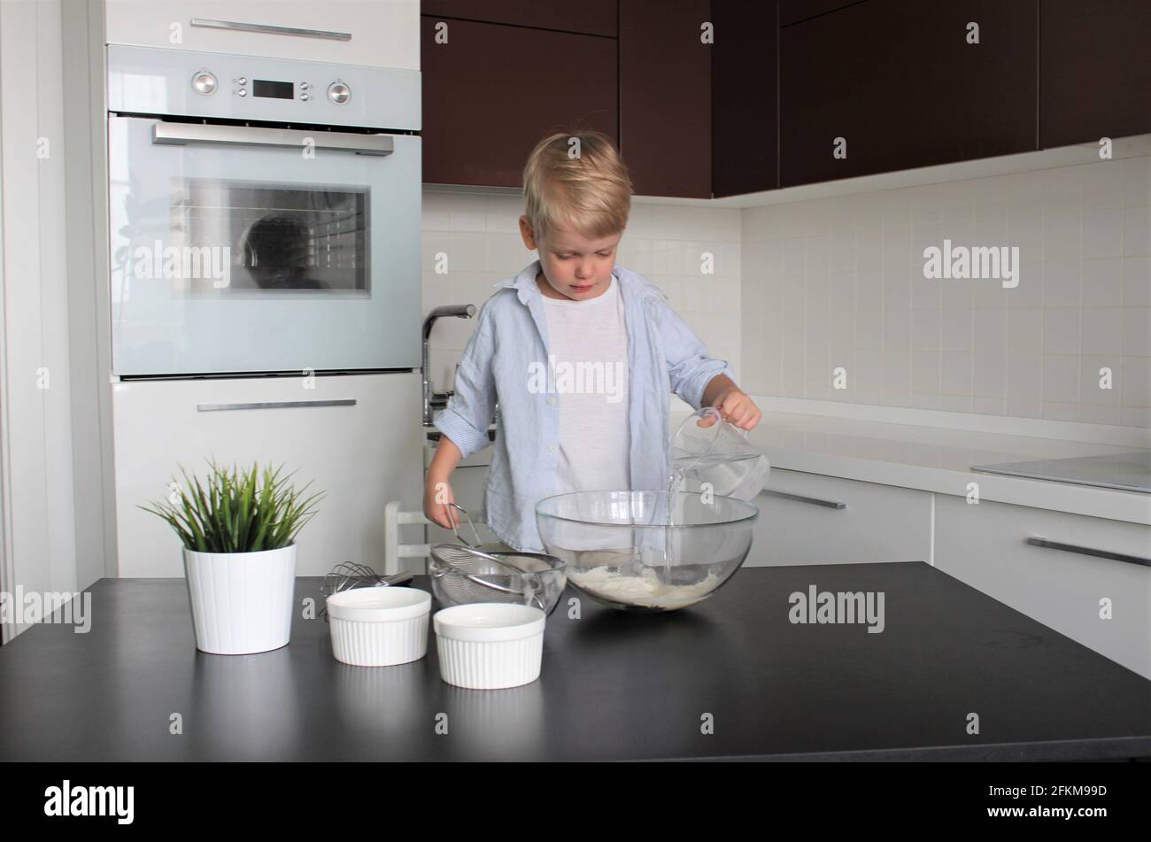 Un enfant de 3 ans cuisine dans la cuisine Banque D'Images