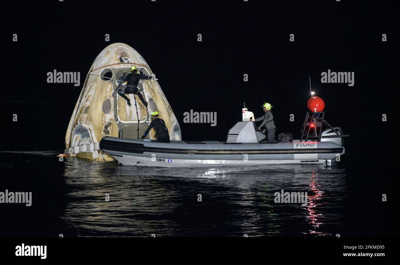 Les équipes de soutien travaillent autour de l'engin spatial SpaceX Crew Dragon Resilience peu après son atterrissage avec les astronautes de la NASA Mike Hopkins, Shannon Walker et Victor Glover, et l'astronaute de l'Agence japonaise d'exploration aérospatiale (JAXA) Soichi Noguchi, dans le golfe du Mexique, au large des côtes de Panama City, en Floride, le dimanche 2 mai 2021. La mission SpaceX Crew-1 de la NASA a été le premier vol de rotation d'équipage du vaisseau spatial SpaceX Crew Dragon et de la fusée Falcon 9 avec des astronautes à destination de la Station spatiale internationale dans le cadre du programme d'équipage commercial de l'agence. Crédit obligatoire : Bill Ingalls/NASA via CNP/MediaP Banque D'Images