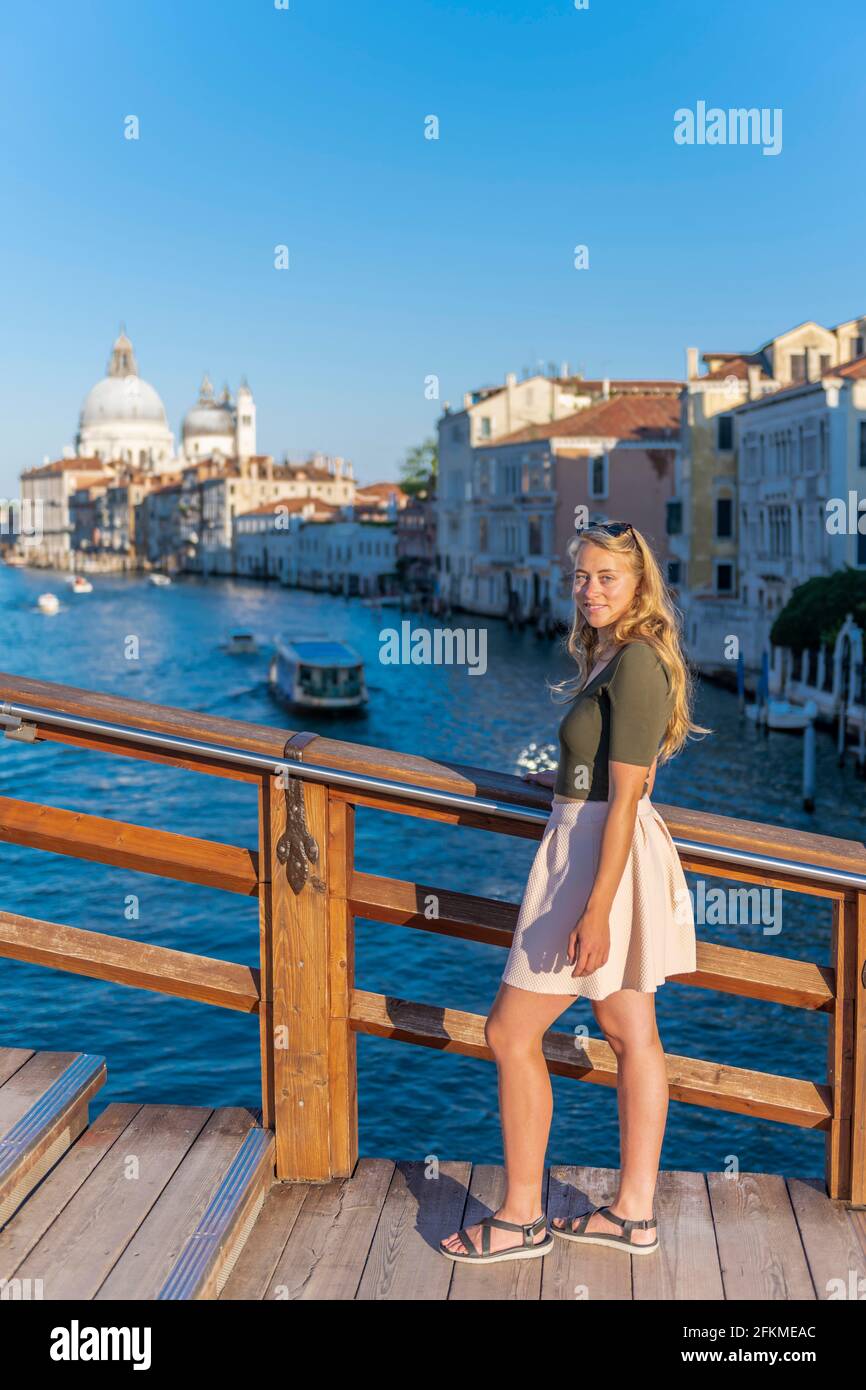 Jeune femme au Ponte dell'Accademia, vue sur le Grand Canal et la basilique de Santa Maria della Salute, Venise, Vénétie, Italie Banque D'Images