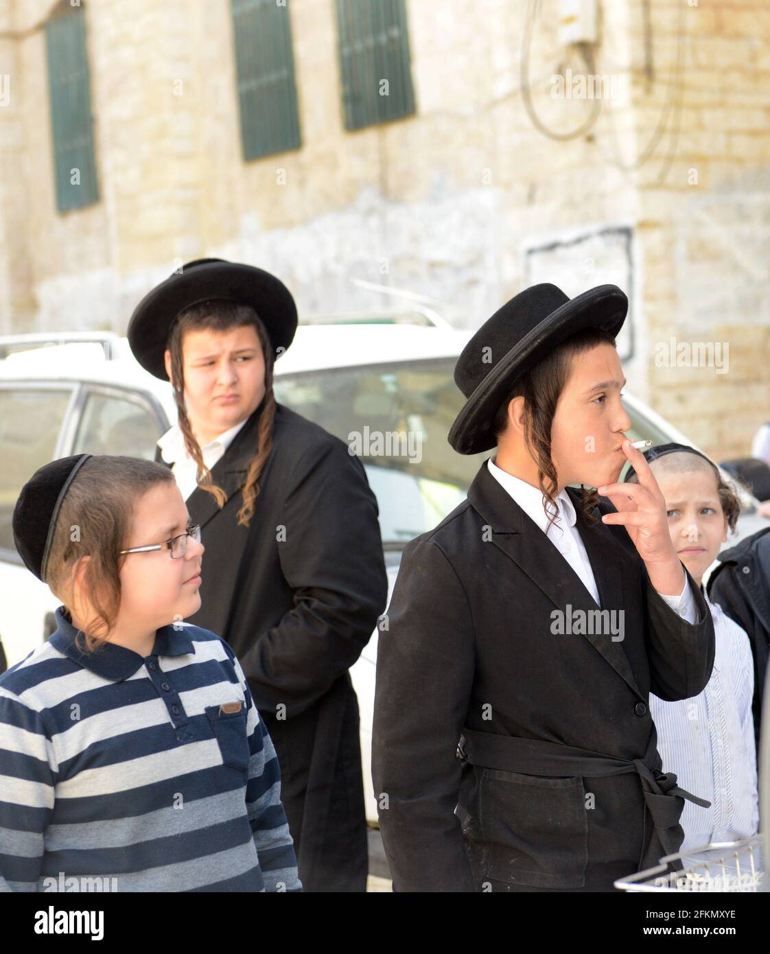 Un adolescent Hassidic Jew fume une cigarette dans le quartier de MEA He'arim à Jérusalem, en Israël. Banque D'Images