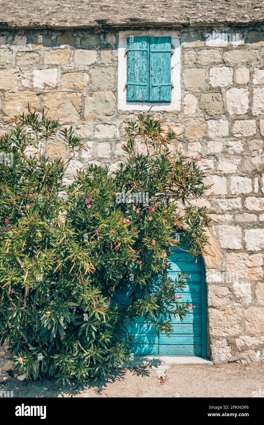 Maison traditionnelle en pierre avec porte bleue et fenêtre en Croatie Banque D'Images