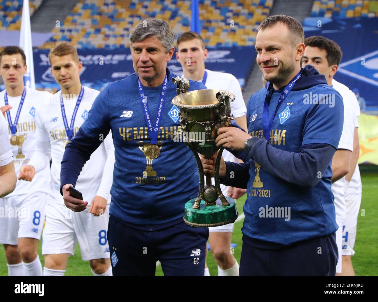 KIEV, UKRAINE - 25 AVRIL 2021 : les entraîneurs adjoints du FC Dynamo Kyiv Emilian Karas (L) et Oleh Husiev posent avec le Trophée des vainqueurs de la première Ligue ukrainienne 2020-21 au stade NSC Olimpiyskiy Banque D'Images