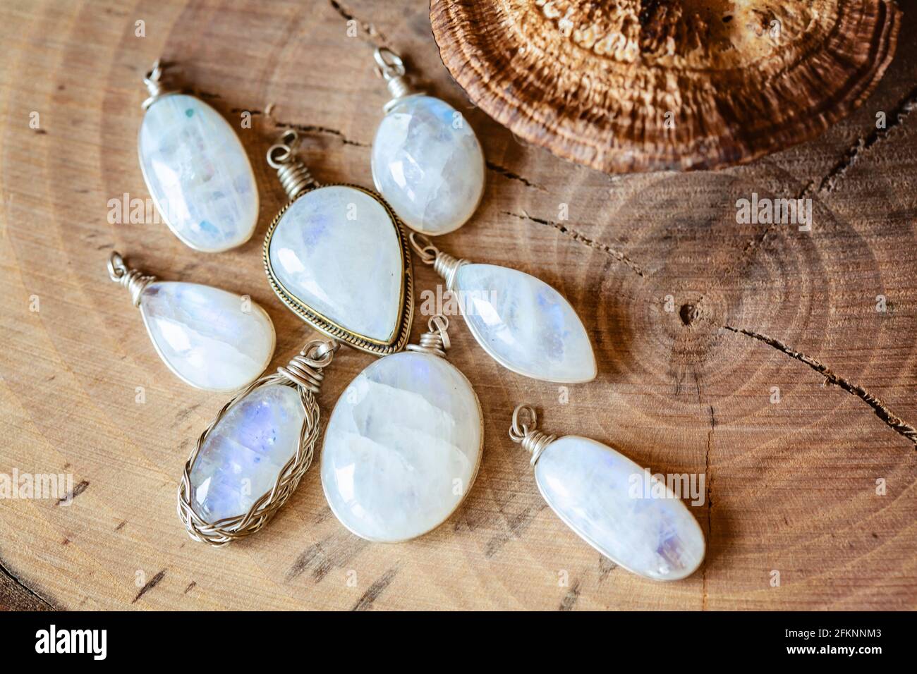Collection de pierres de lune pierres gemmes bijoux pendentifs sur bois naturel arrière-plan Banque D'Images