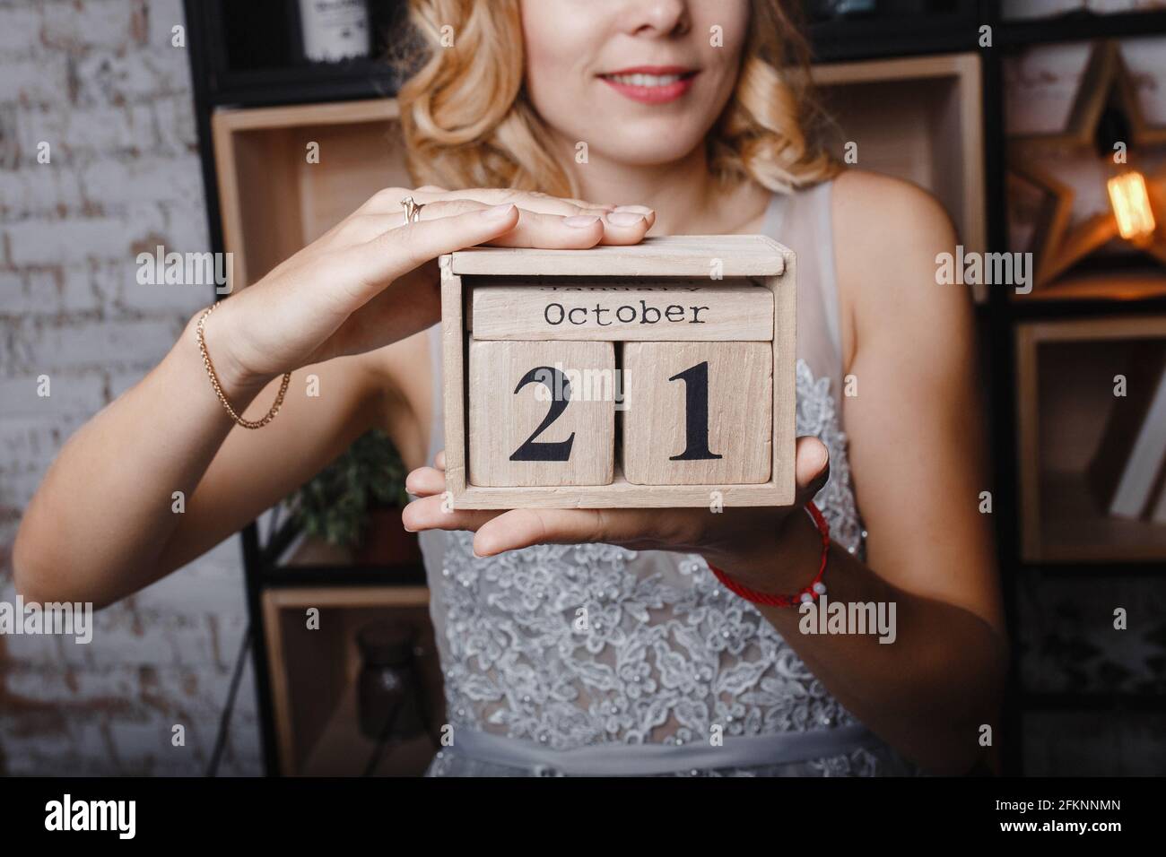 Octobre 21. 21e jour du mois. Cube de calendrier entre les mains d'une jeune fille, le concept d'entreprise et un événement important. Banque D'Images