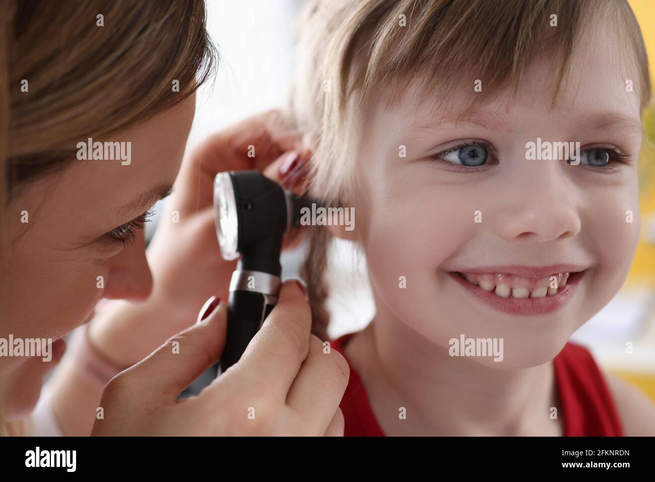 ORL médecin examinant l'oreille douloureuse du petit enfant à l'aide d'un otoscope Banque D'Images