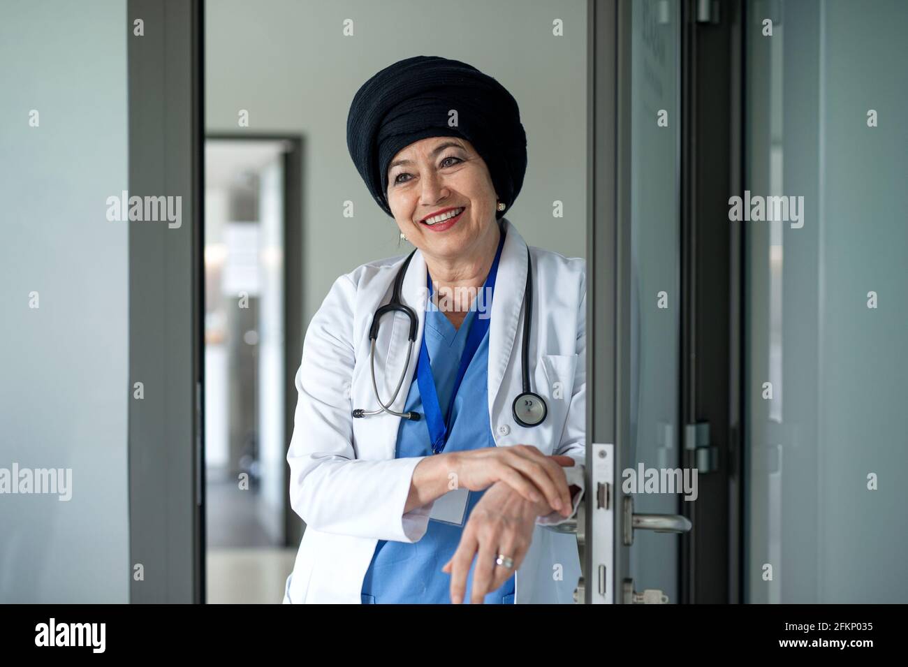 Portrait d'une femme âgée médecin debout à l'hôpital, regardant la caméra. Banque D'Images