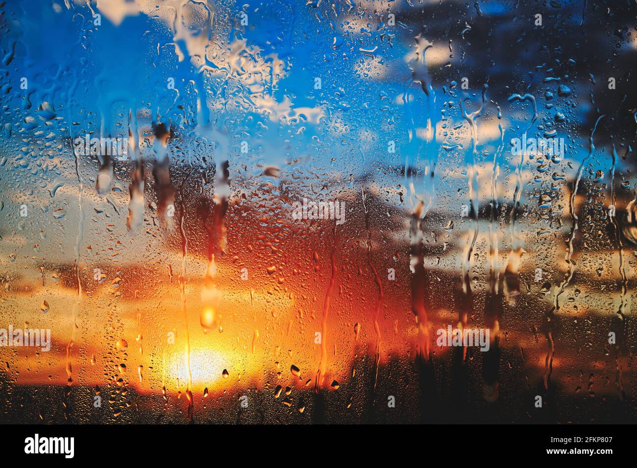 Coucher de soleil d'été brillant derrière le verre goutte à goutte après la pluie Banque D'Images