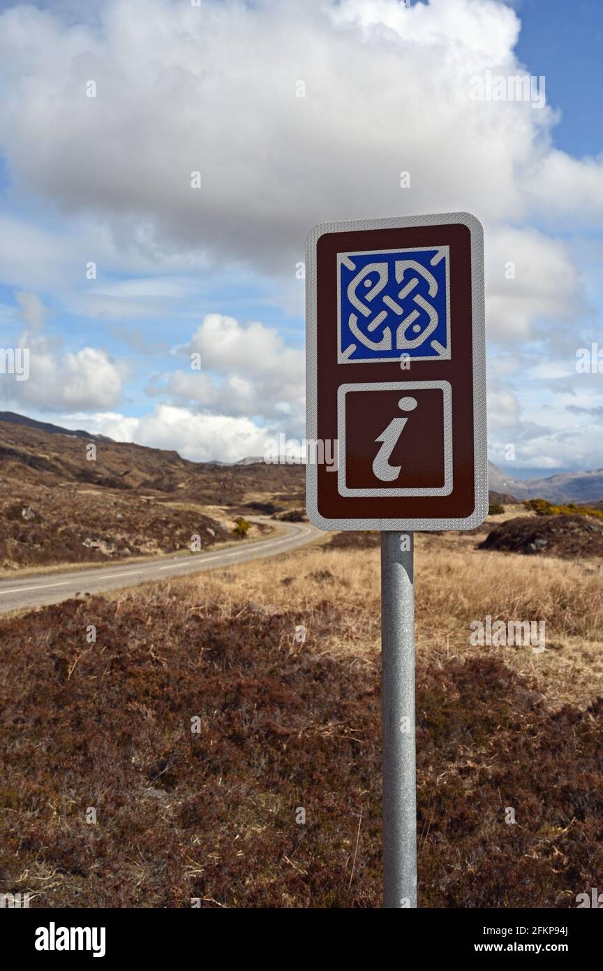 Panneau Geopark North West Highlands avec icône d'information. Sur la route NC500. Arrière-plan flou de la route et de la lande, ciel bleu et nuages. Banque D'Images