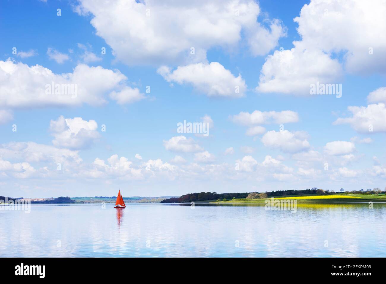 Réservoir d'eau de Rutland - un bateau à voile ou un yacht avec voiles rouges sur le réservoir d'eau de Rutland Oakham Rutland Angleterre GB Europe Banque D'Images
