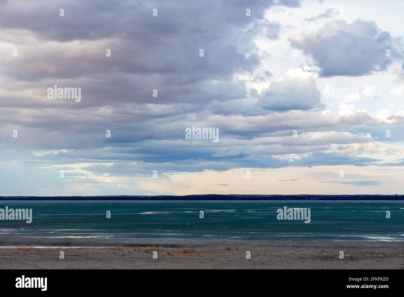 plage côtière et eau avec fonte de glace lac au printemps avec de beaux nuages dans le ciel pendant le coucher du soleil Banque D'Images