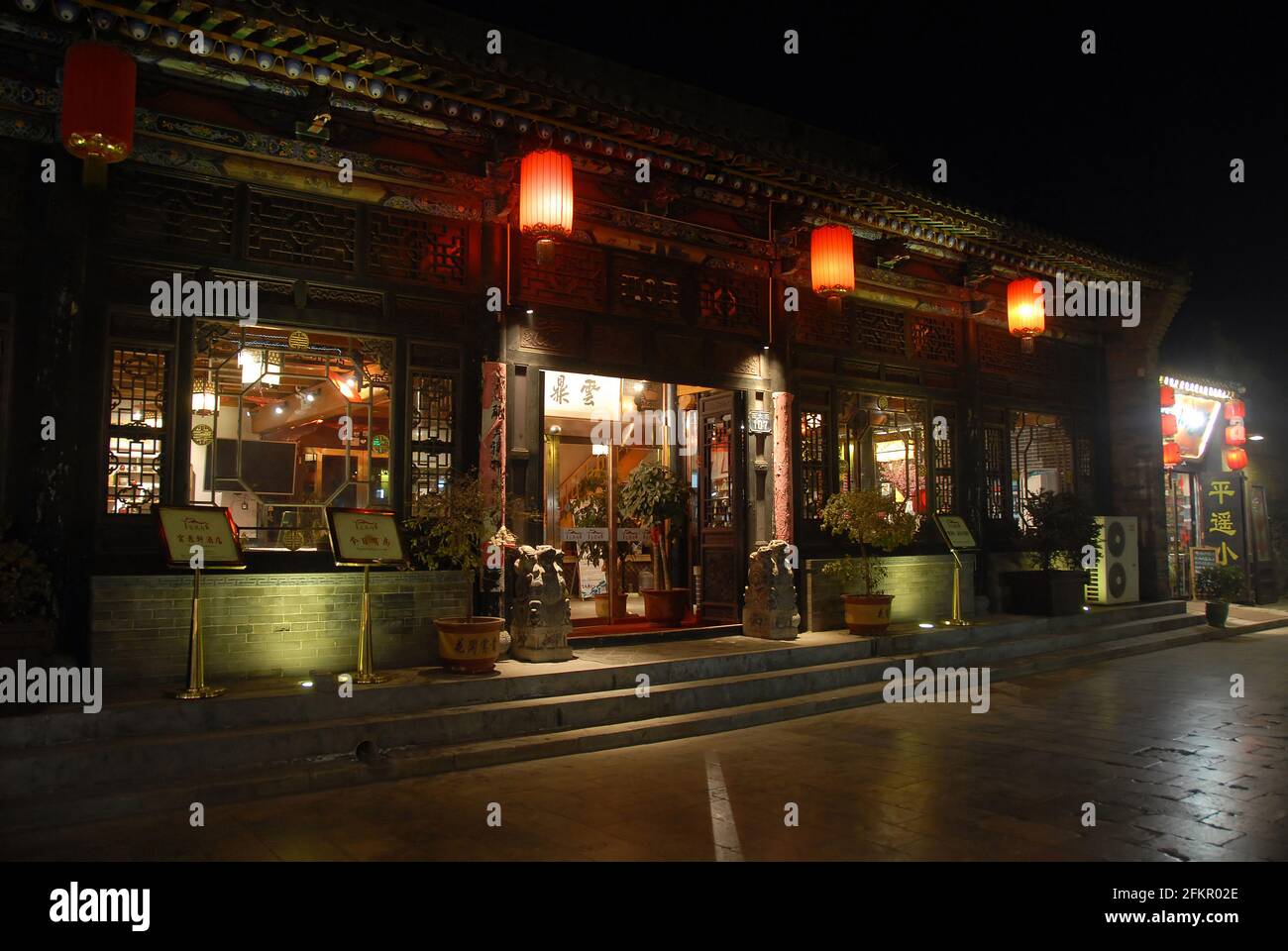 Pingyao dans la province du Shanxi, Chine: Rue à Pingyao la nuit avec un restaurant traditionnel et des lanternes rouges. Banque D'Images
