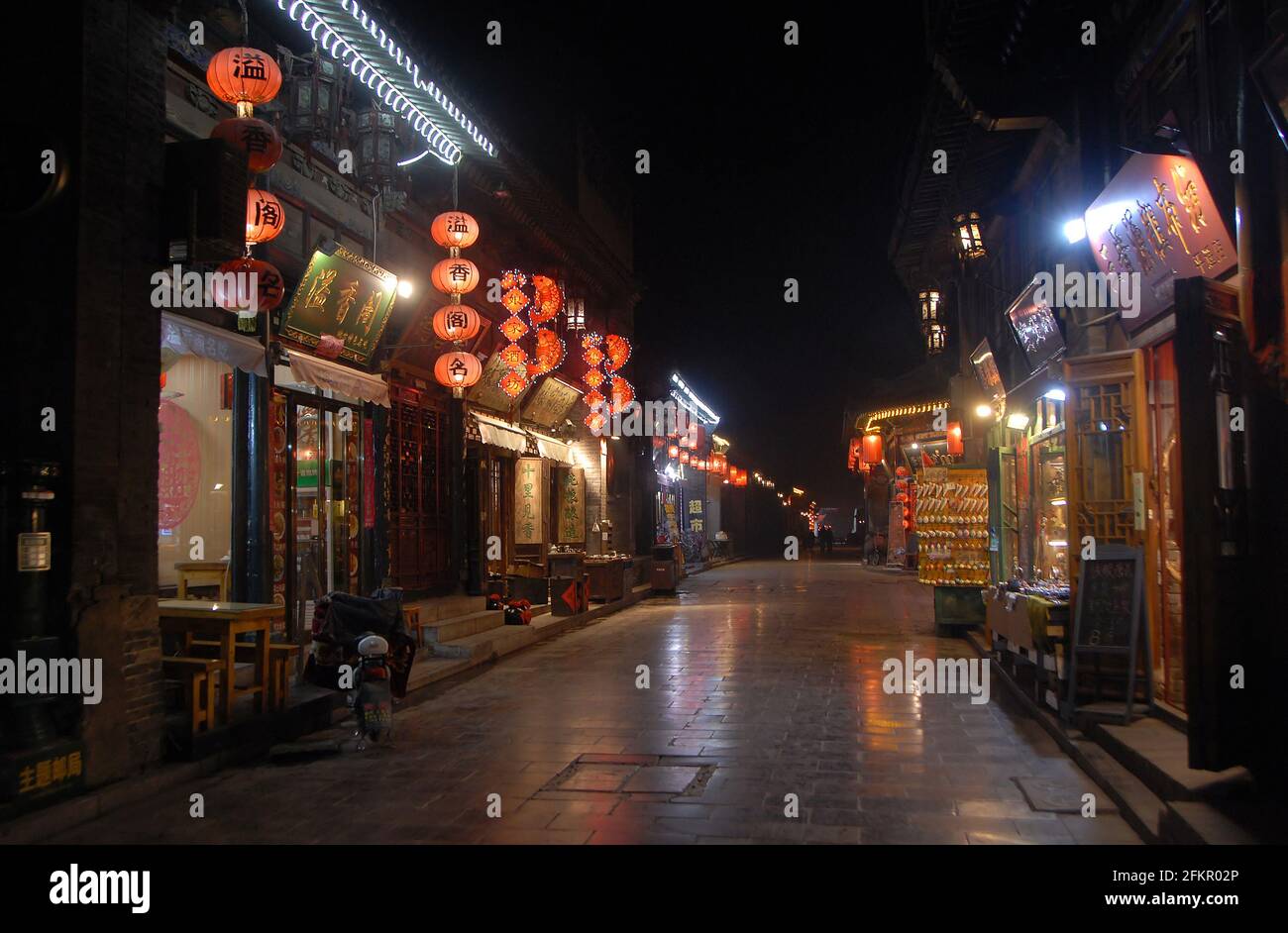 Pingyao dans la province du Shanxi, Chine: Scène de rue à Pingyao la nuit avec lumières de la ville et lanternes rouges. Rue avec restaurants et magasins à Pingyao. Banque D'Images