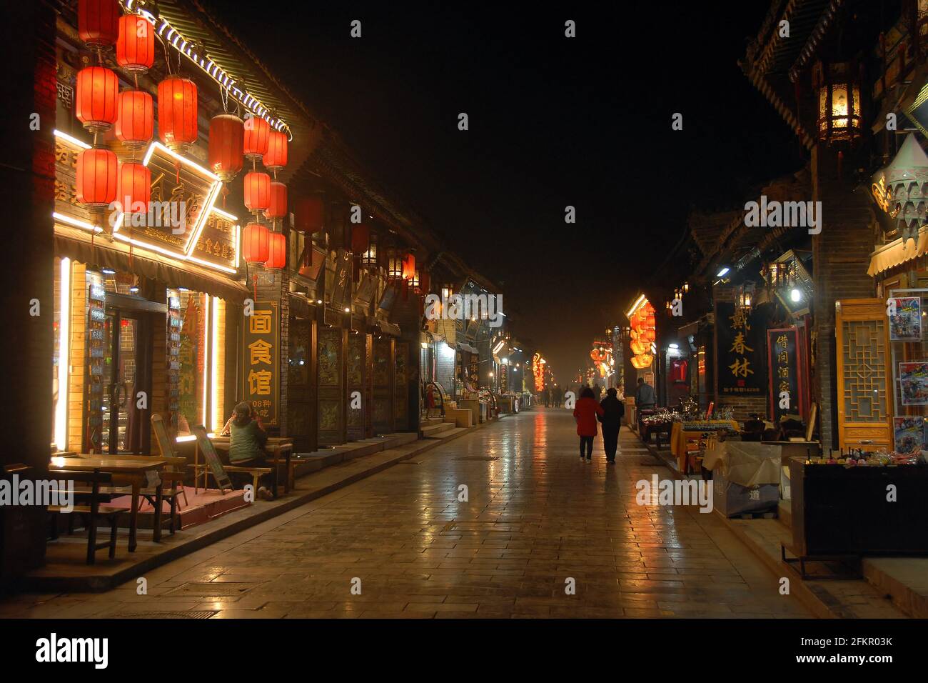 Pingyao dans la province du Shanxi, Chine: Scène de rue à Pingyao la nuit avec lumières de la ville et lanternes rouges. Rue avec restaurants et magasins à Pingyao. Banque D'Images