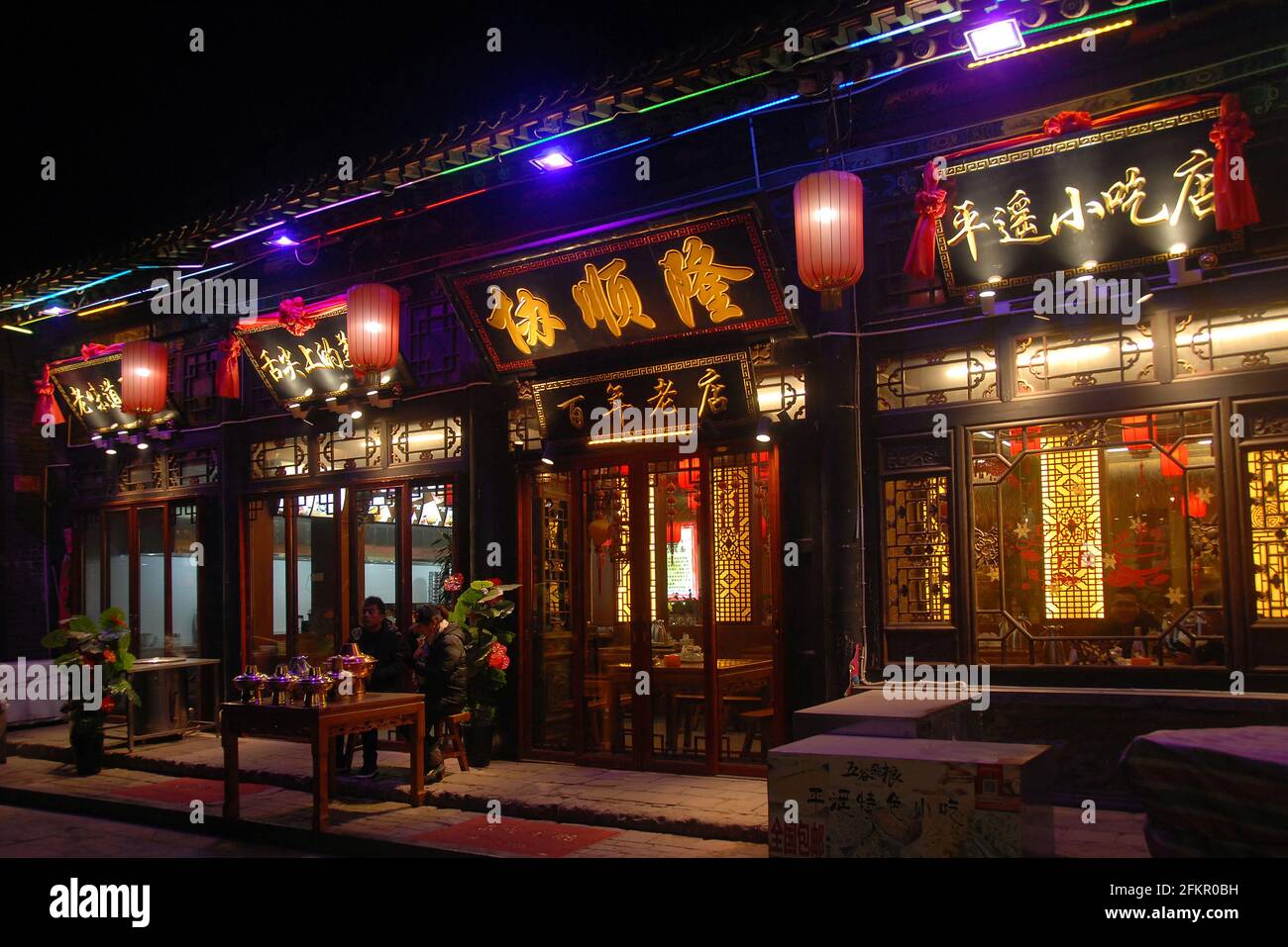 Pingyao dans la province du Shanxi, Chine: Rue à Pingyao la nuit avec un restaurant traditionnel et des lanternes rouges. Banque D'Images