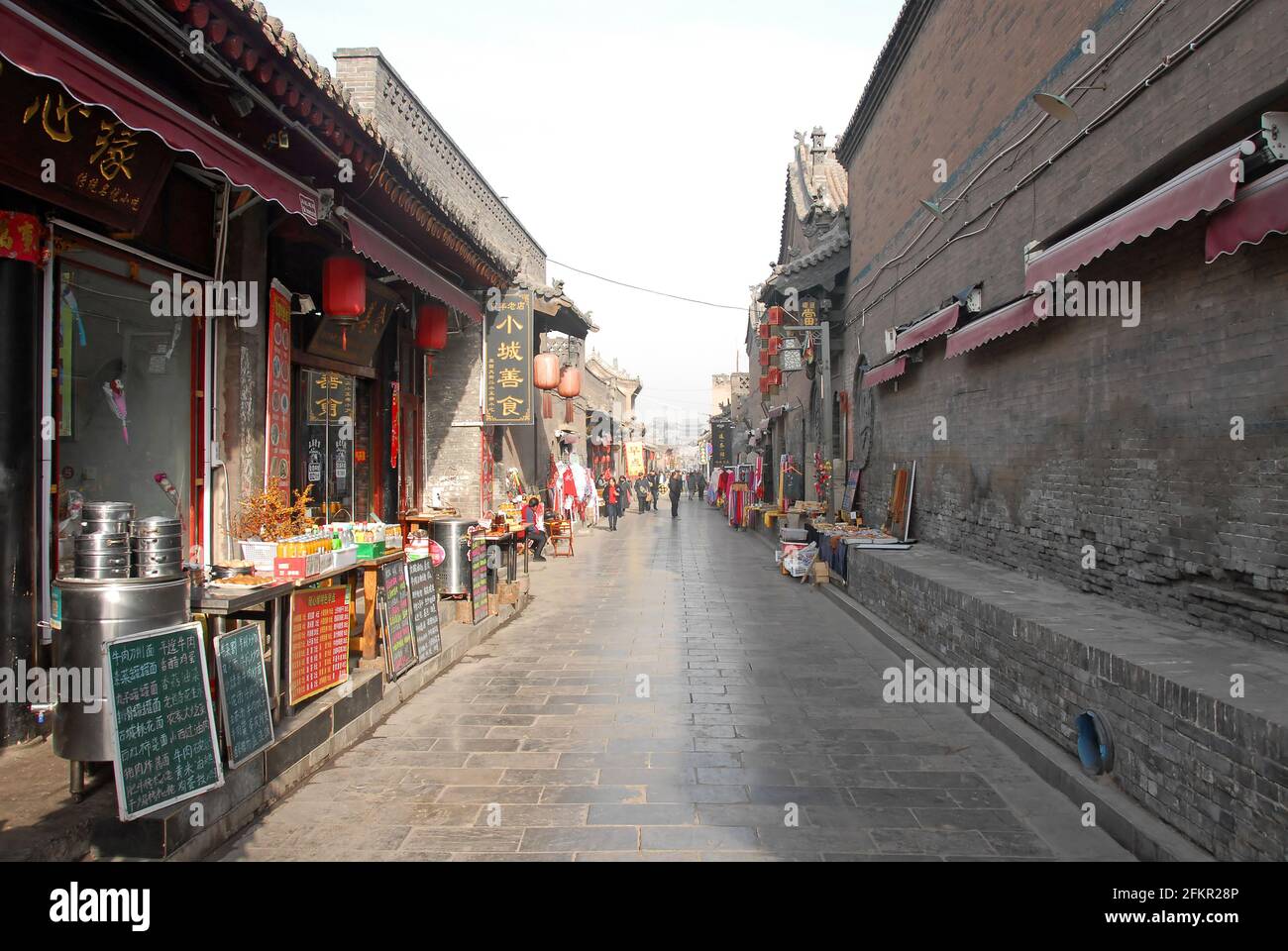Une petite rue à Pingyao, province du Shanxi, Chine bordée de restaurants et de boutiques. Les menus sont en face des restaurants. Banque D'Images