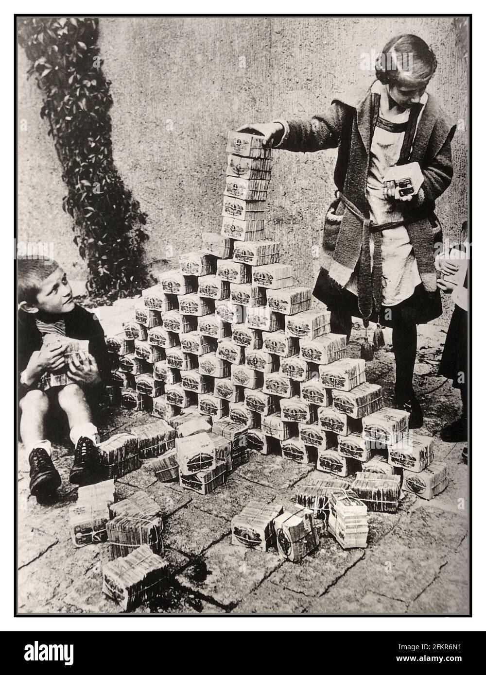 ALLEMAGNE WEIMAR INFLATION des années 1920 Archive hyperinflation Allemagne, enfants utilisant des billets de banque comme jouets, Allemagne, années 1920. Entre 1921 et 1923, l'hyperinflation a affecté le Papiermark allemand, la monnaie de la République de Weimar, principalement en 1923. Elle a provoqué une instabilité politique interne considérable dans le pays, l'occupation de la Ruhr par la France et la Belgique ainsi que la misère de la population en général. Imprimer plus d'argent est exactement ce que l'Allemagne de Weimar a fait en 1922. L'hyperinflation a conduit à l'effondrement de l'économie. Banque D'Images