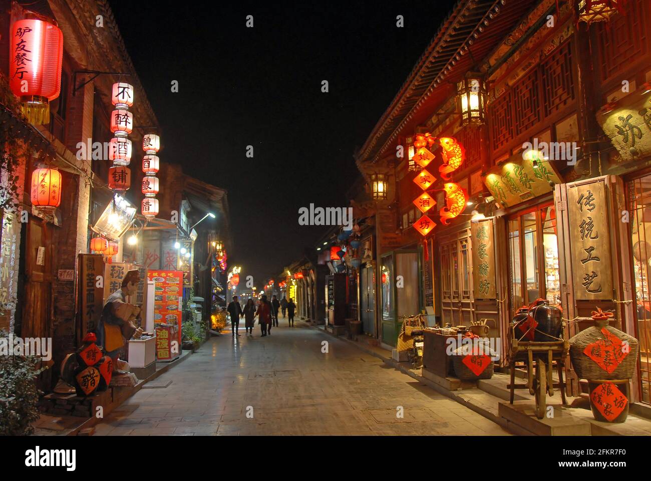 Pingyao dans la province du Shanxi, Chine: Scène de rue à Pingyao la nuit avec lumières de la ville et lanternes rouges. Banque D'Images