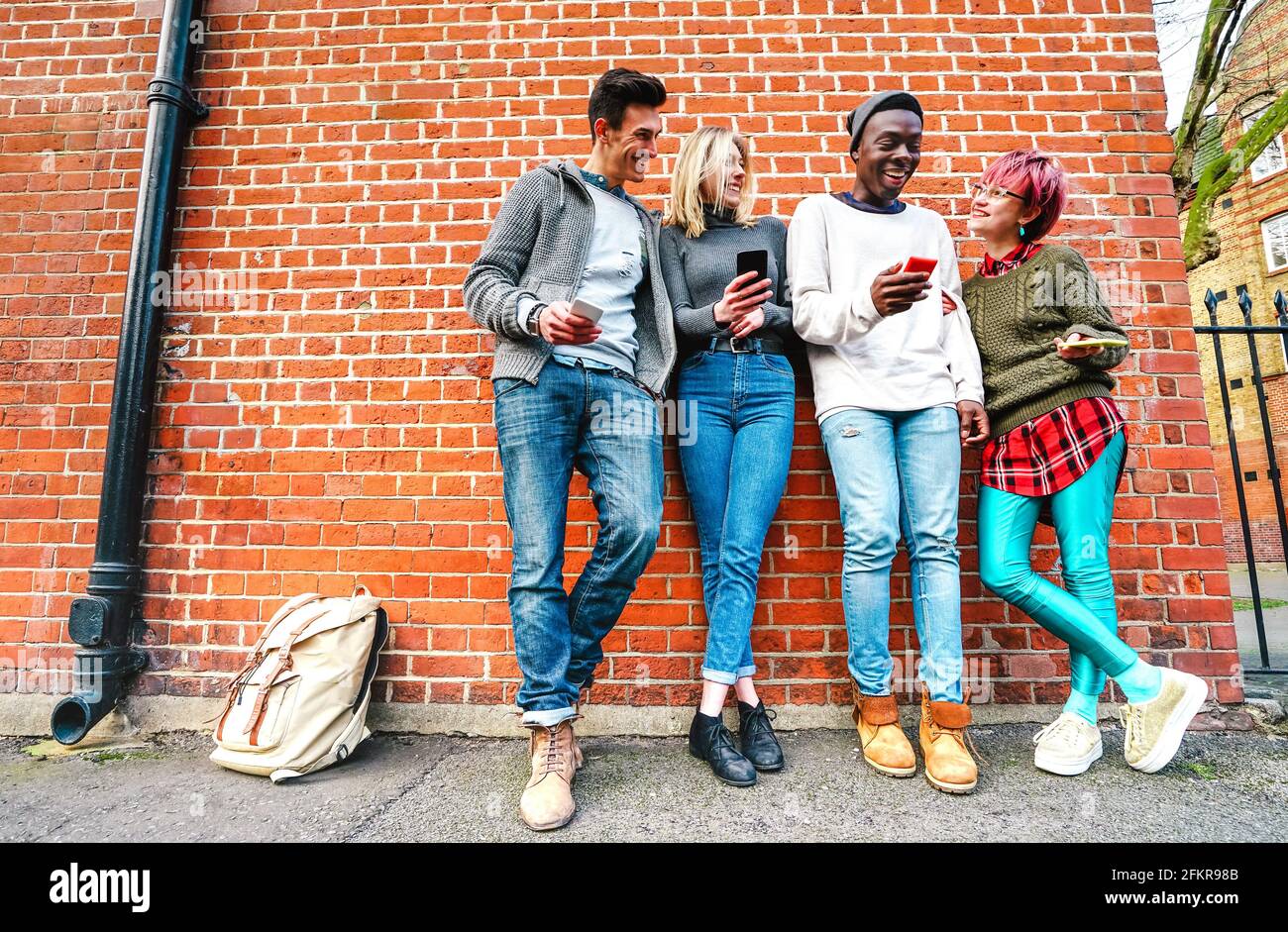 Amis multiculturels de taille basse partageant du contenu sur smartphone dans les zones urbaines À Shoreditch Londres - les gens de Millenial et de plaisir addictif avec téléphone portable Banque D'Images
