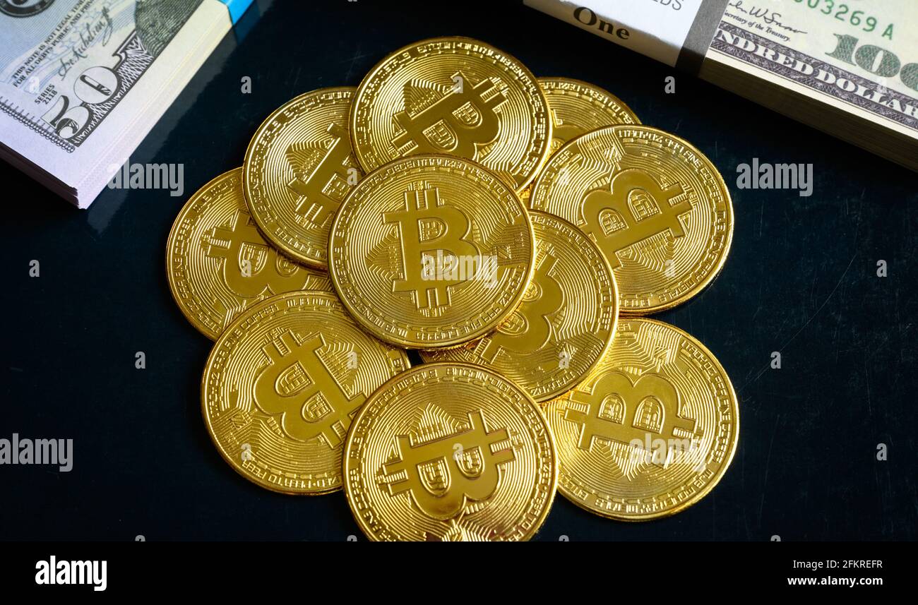 Bitcoin avec des piles de dollars en espèces, crypto virtuel numérique bitcoin en monnaie et de l'argent papier. Les billets EN dollars AMÉRICAINS et les pièces en bits d'or s'accumulent. Concept de en ligne b Banque D'Images